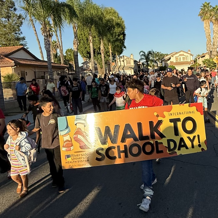 students walking to school with a sign