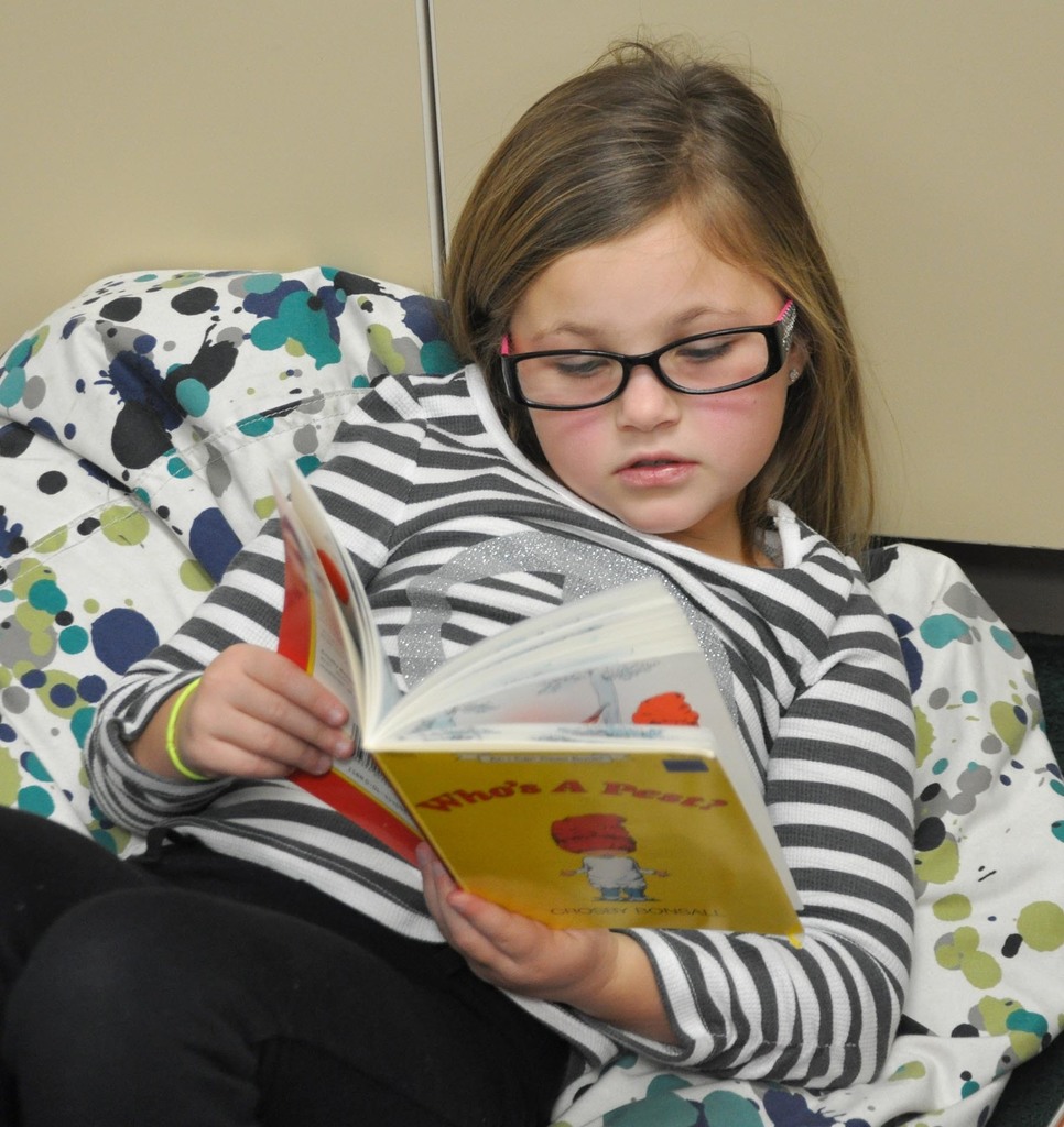 An elementary student reading a book. 