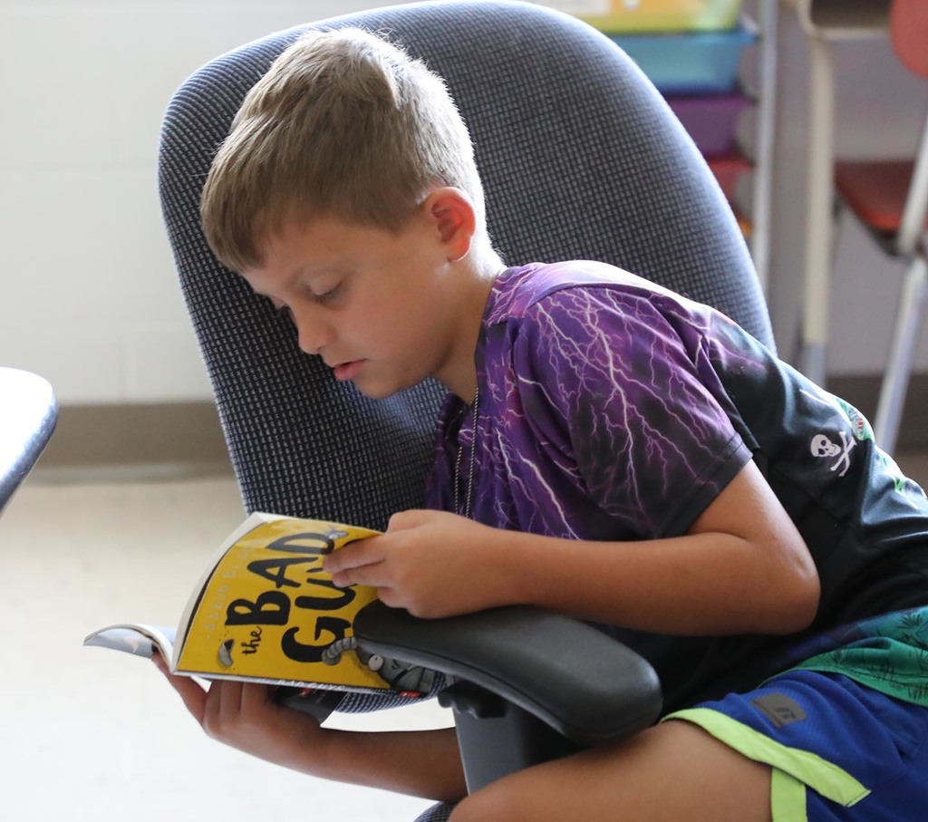 An elementary boy reading a book.