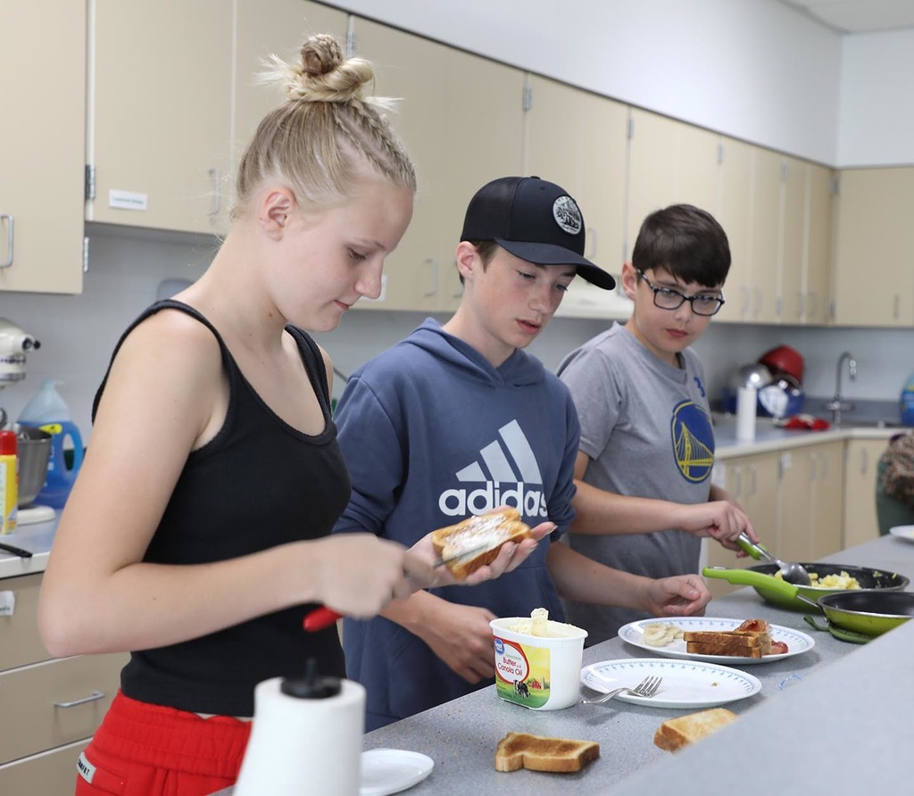 Three JH students preparing food together. 