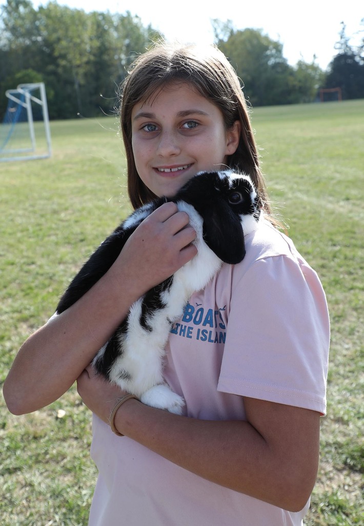 An elementary girl holding a bunny.
