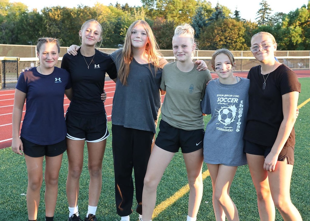 A group of jr. high girls standing on a football field. 