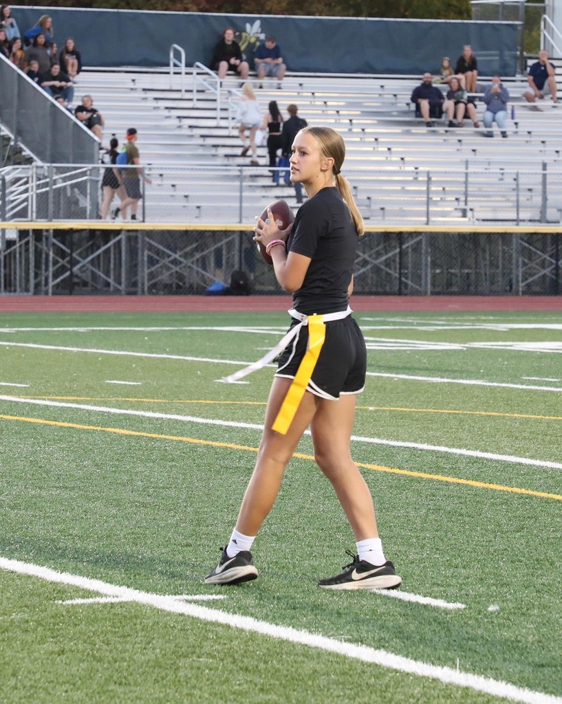 A girl quarterback looking to throw a football. 