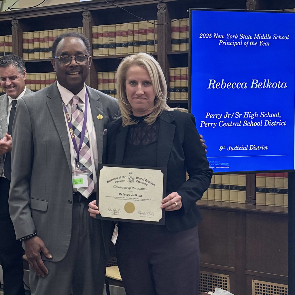 An adult female holding a certificate and standing next to an adult male. 