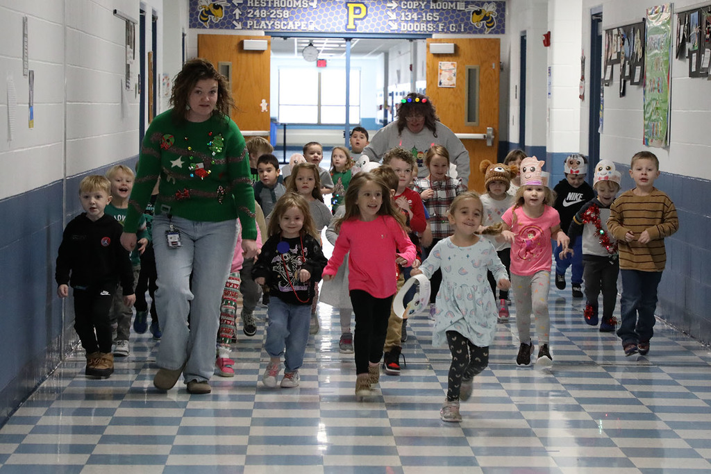 A group of UPK students running down a school hallway. 