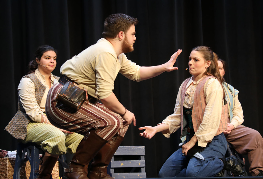 Four actors on a stage. 
