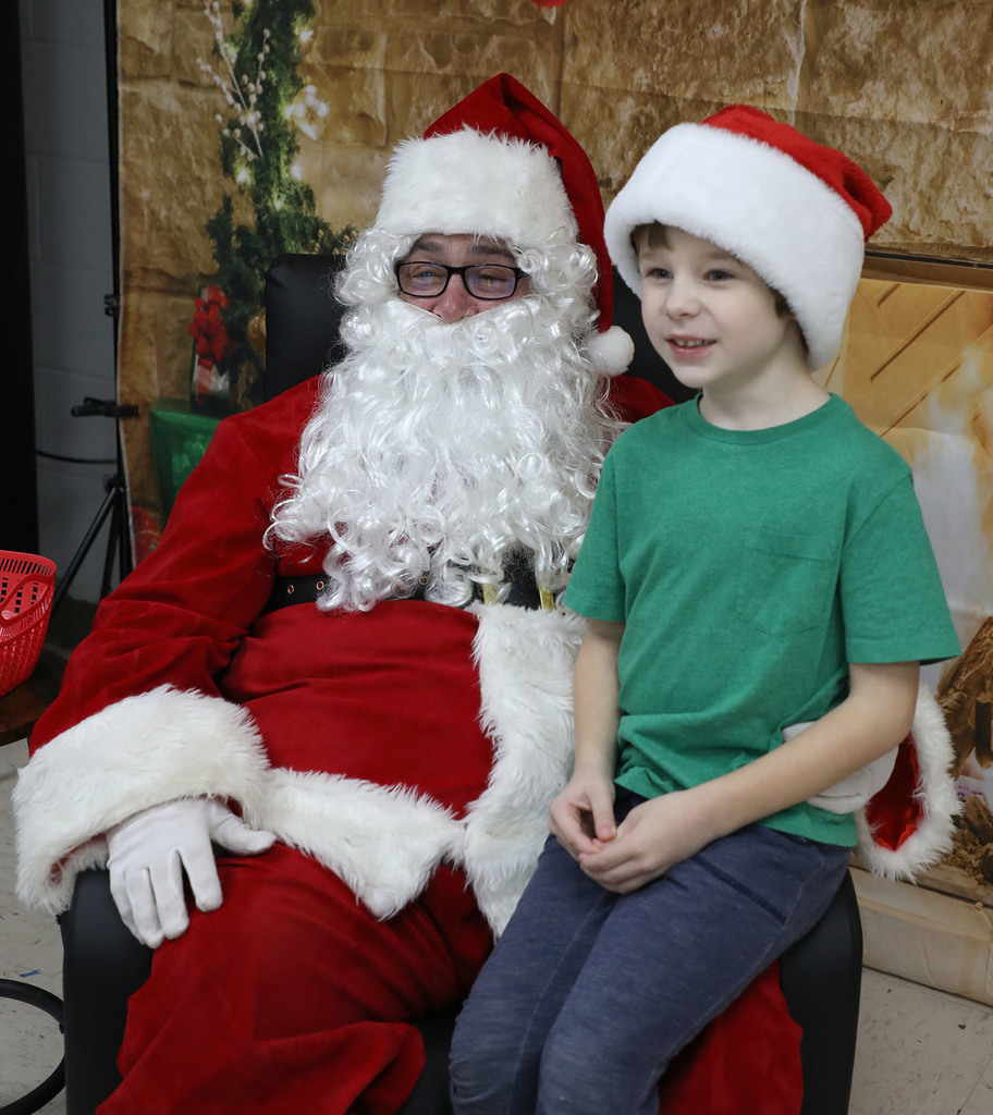 A young boy sitting on Santa's lap. 