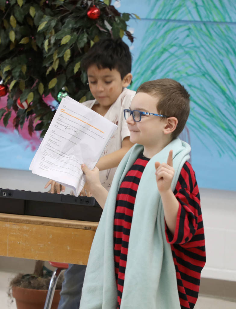 Two male elementary students acting out "A Charlie Brown Christmas." 