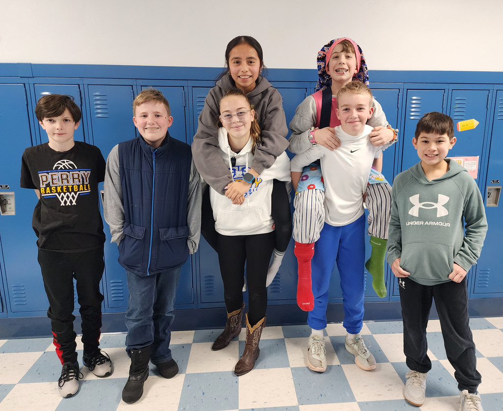 A group of students posing in a school hallway together. 