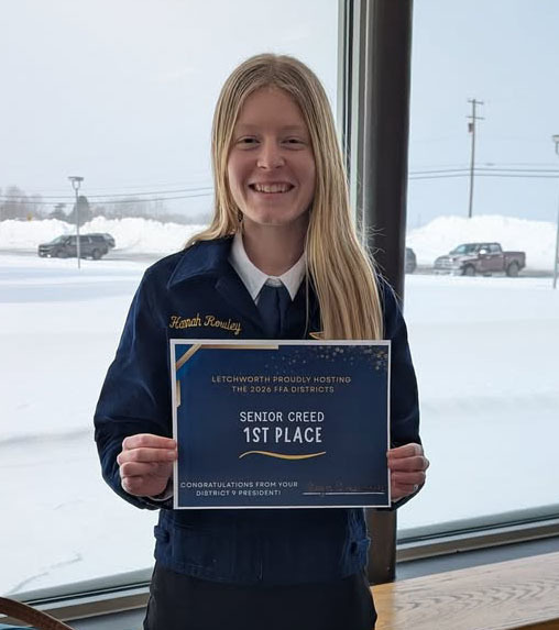 A teenage girl holding a first place certificate.