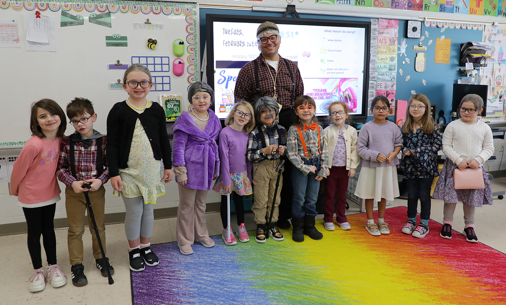 A group of second graders and their teacher posing for a photo. 