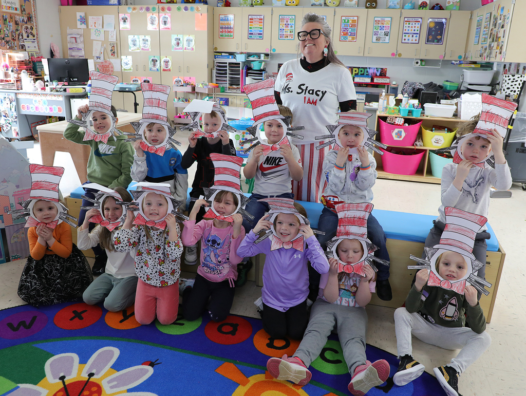 A group of UPK students, and one adult, with Cats in the Hat masks. 