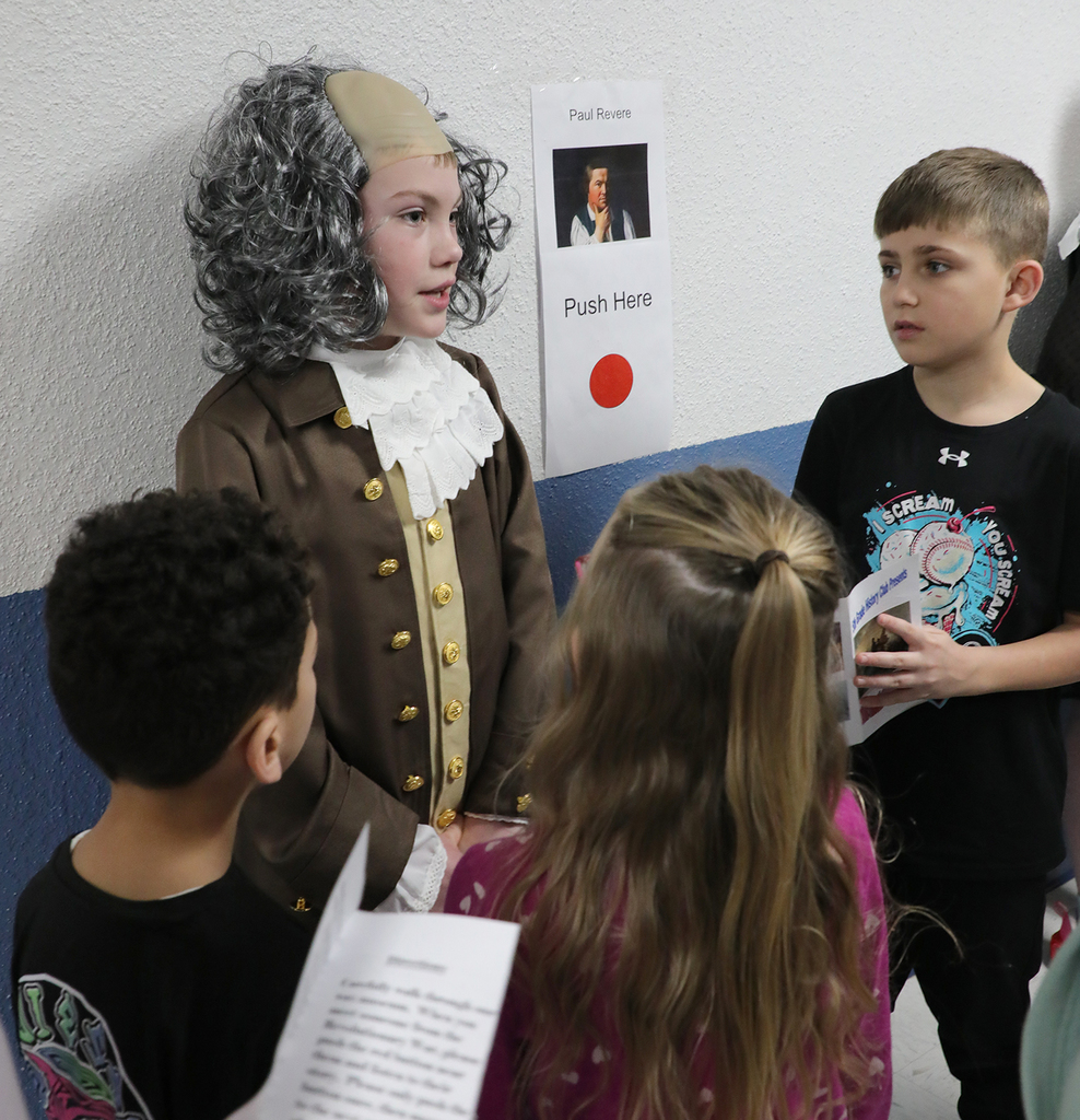 A student dressed as Paul Revere talking to other students. 