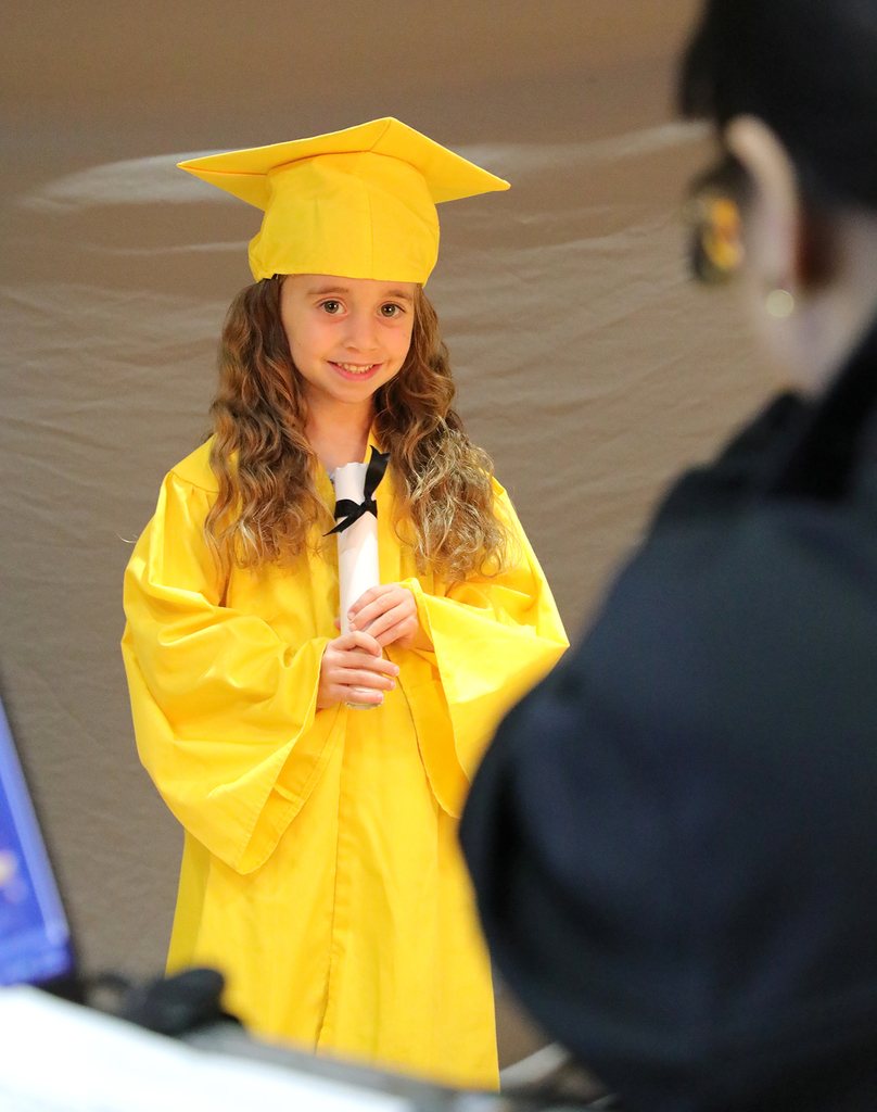 A UPK student posing for a graduation photo. 
