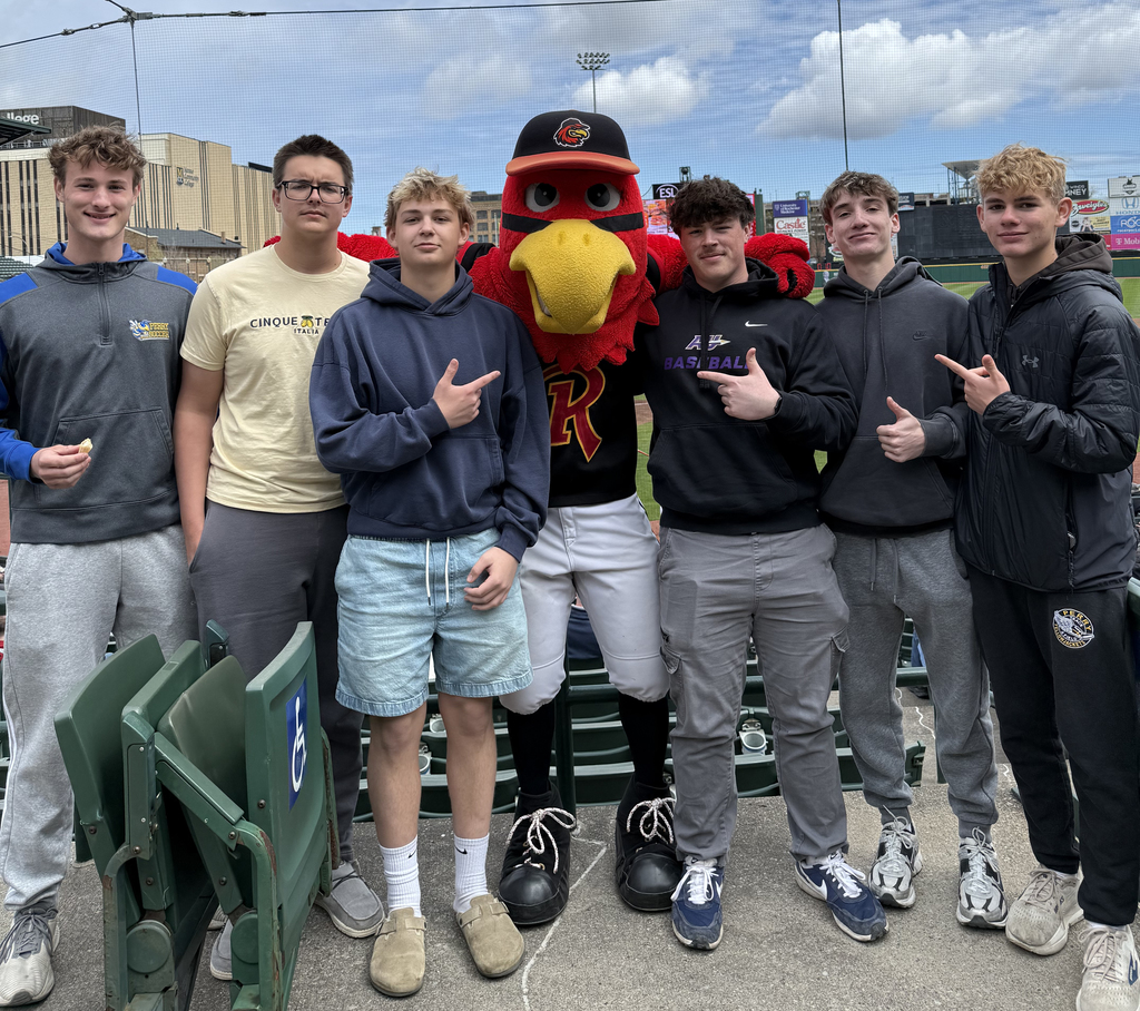 High school boys posing with a team mascot. 
