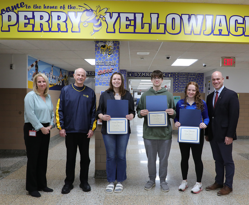Three adults standing with three high school students. 