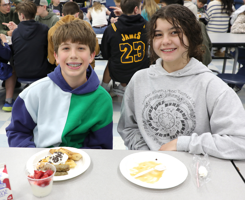 Two students sitting in a school cafeteria. 