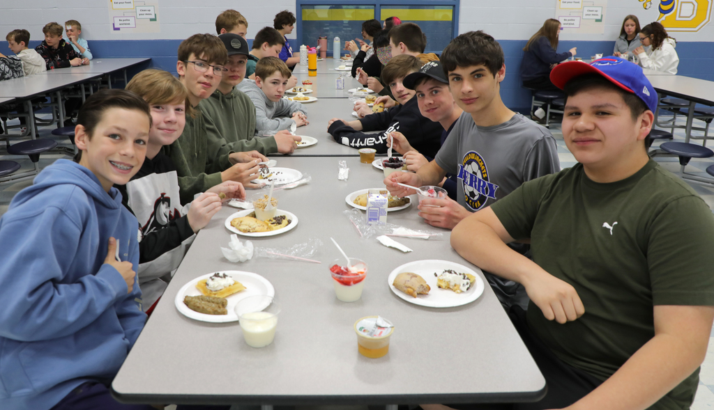 A group of students sitting in a school cafeteria. 