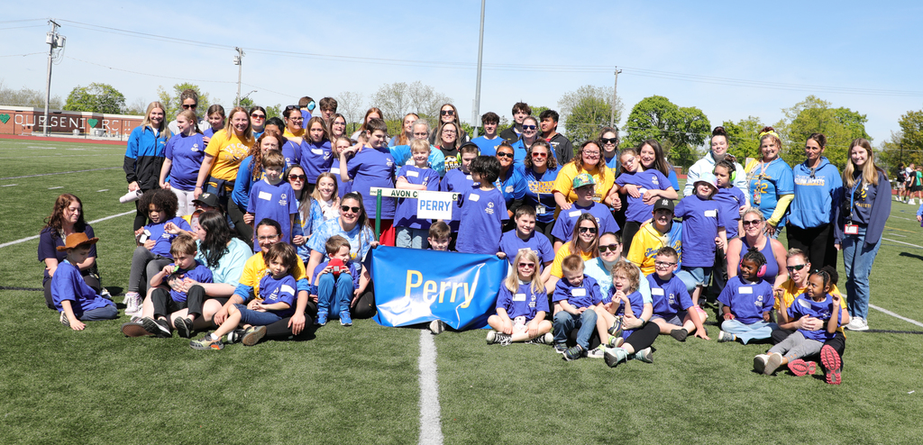 A group of children and adults on a football field.