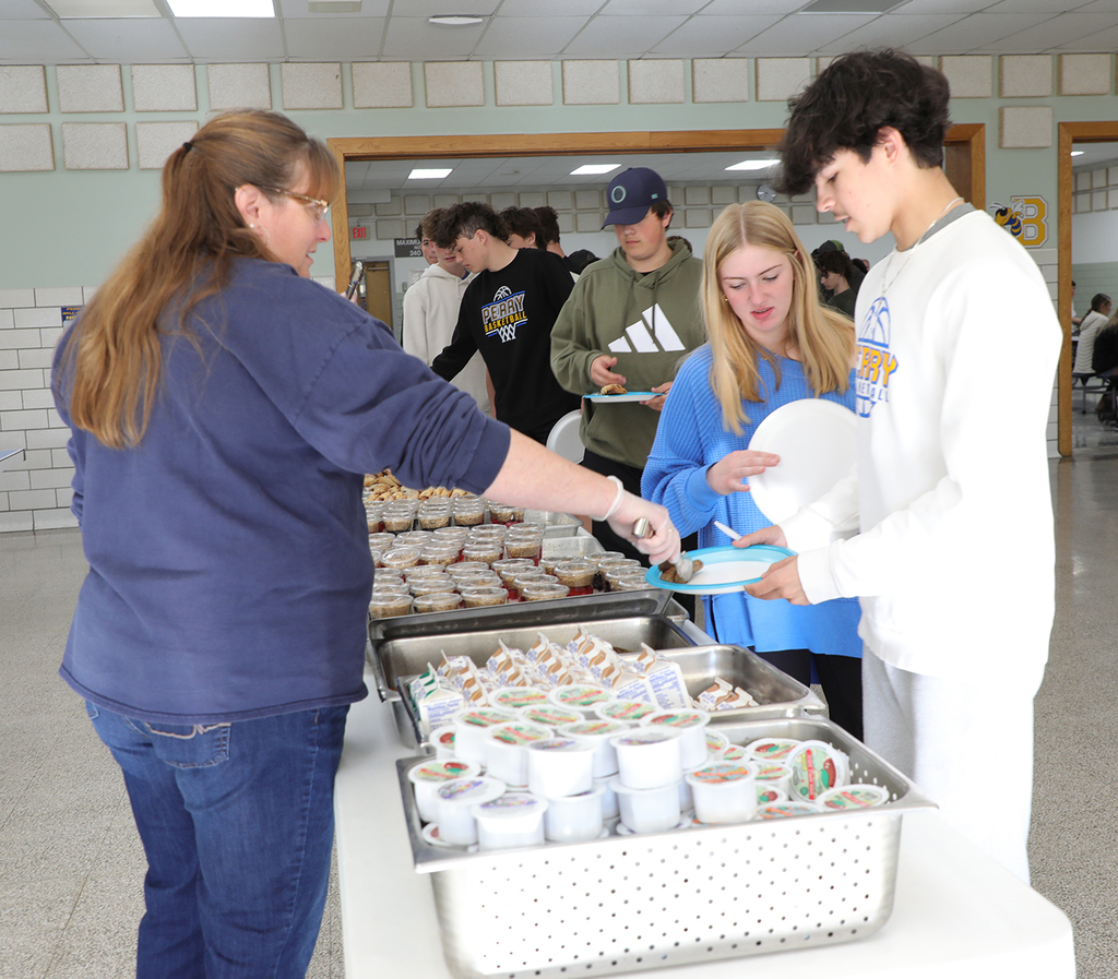 Students being served in a high school cafeteria. 