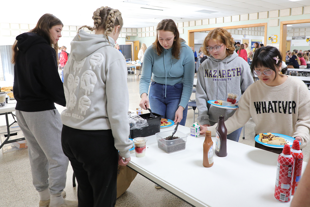High school students at a waffle station. 