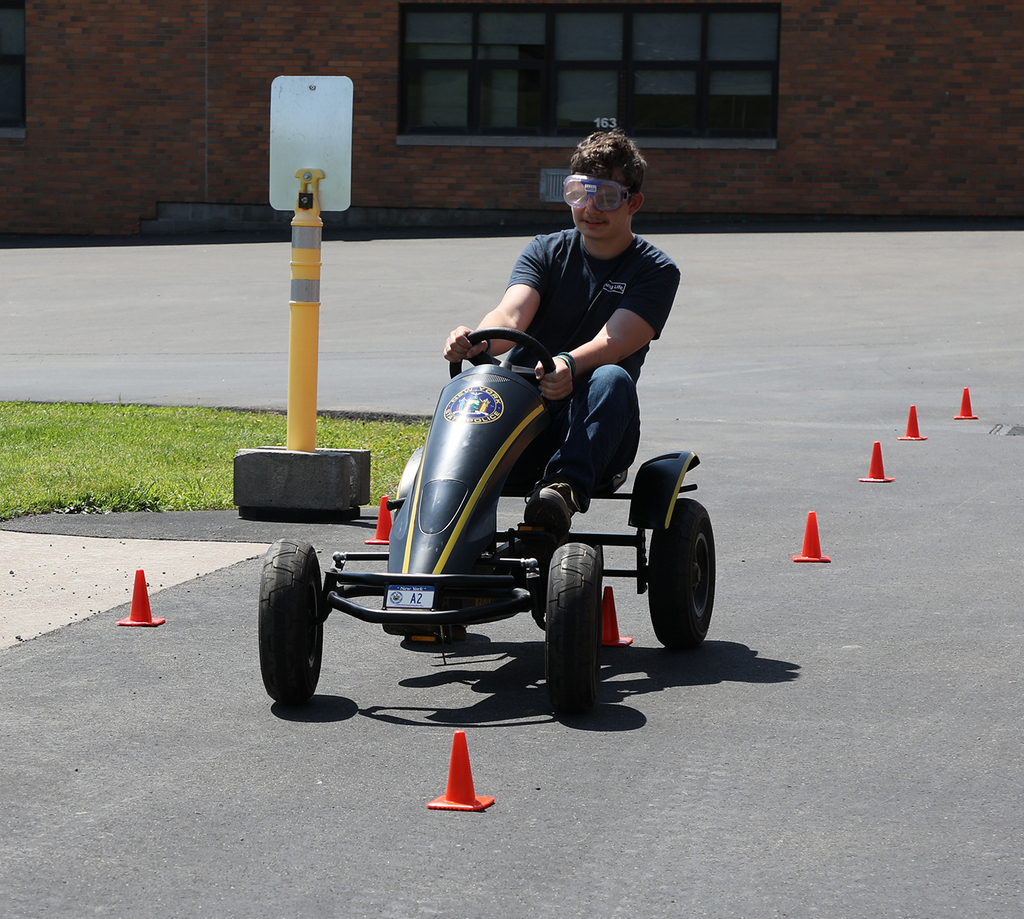 A high school students on a peddle car. 