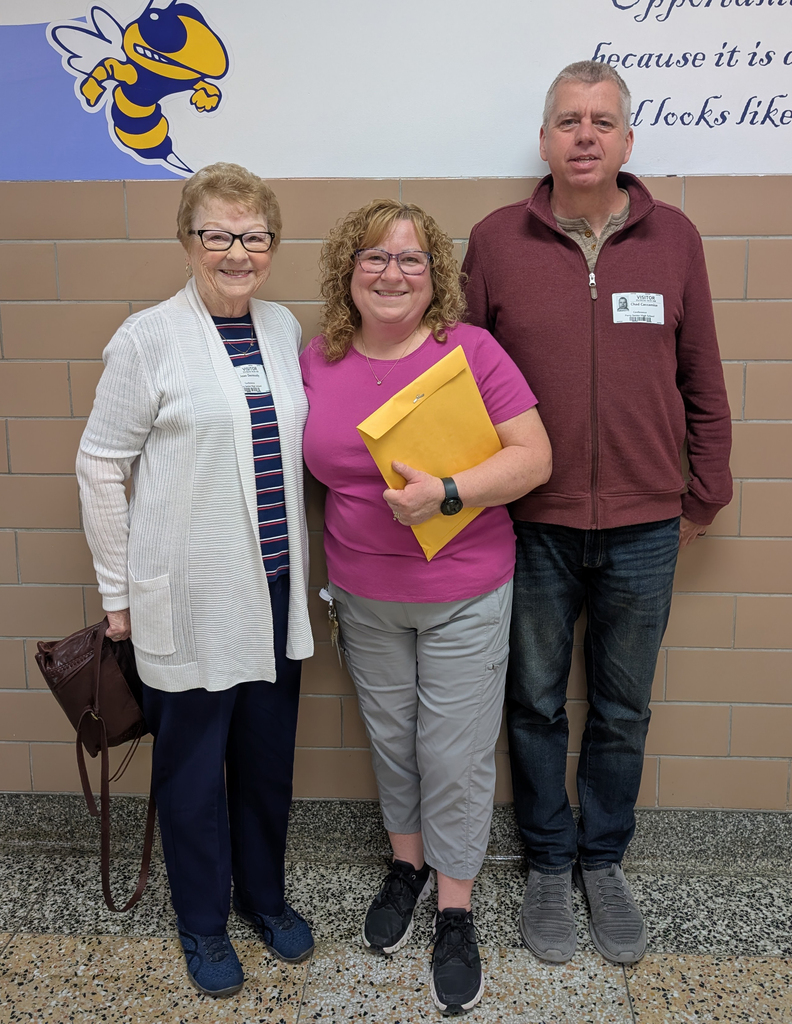 Three adults standing together. 