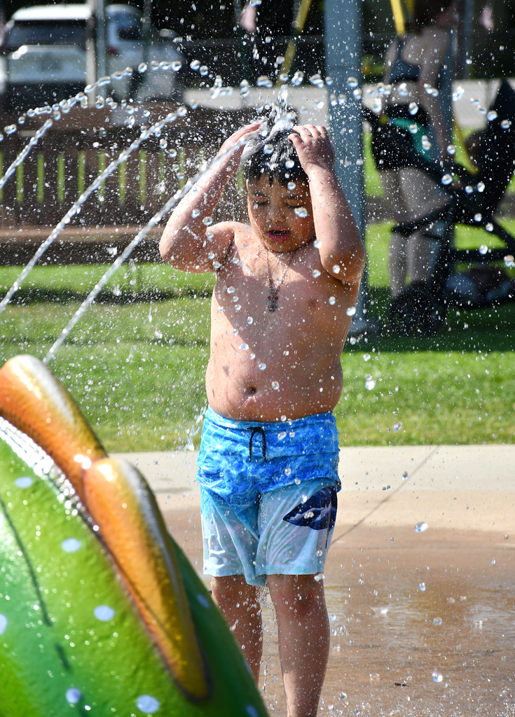 A boy playing at a splash pad. 