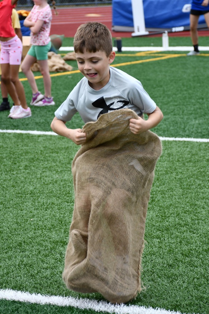 A boy competing in a potato sack race. 