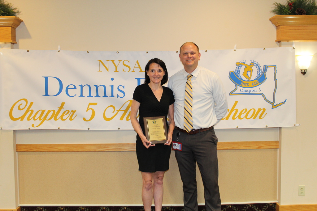 A woman holding an award. She is standing next to a man. 