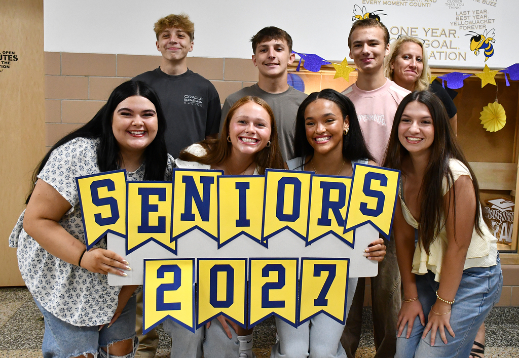 A group of seniors and a principal posing for a photo. 