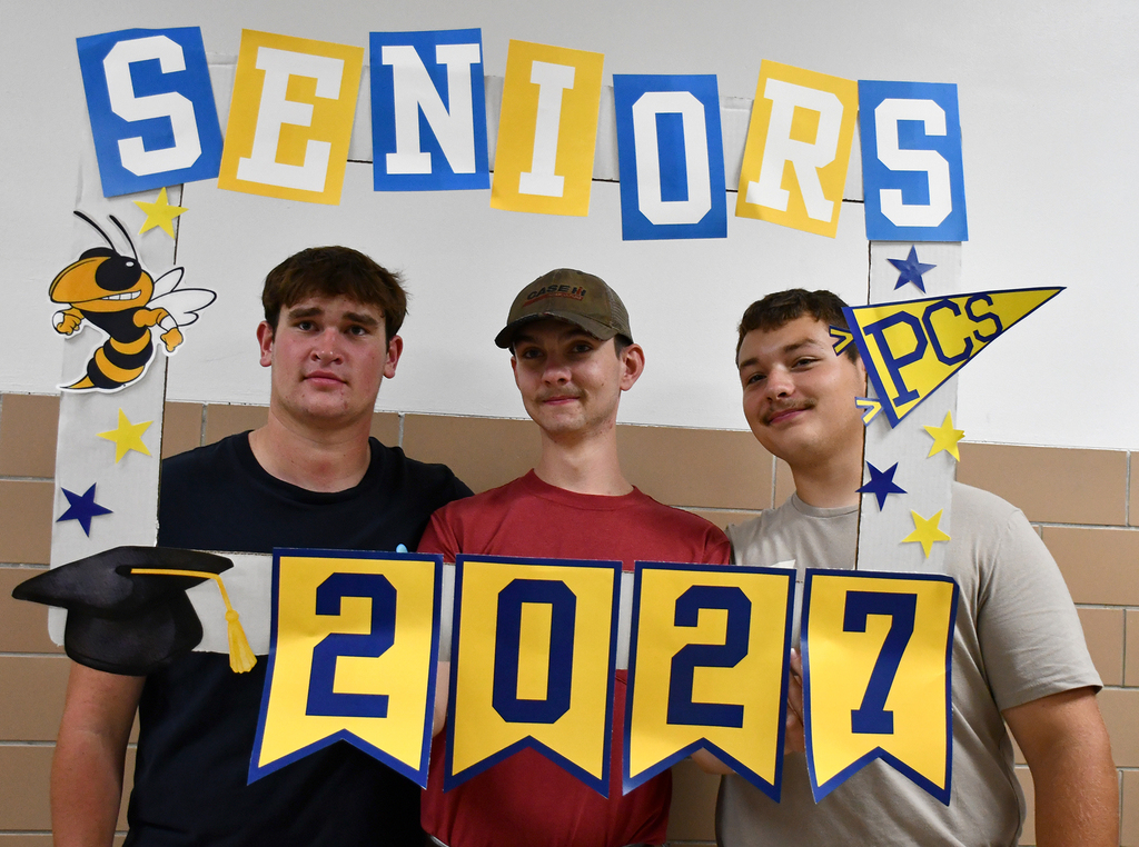 Three boys posing with a sign "Seniors 2027." 