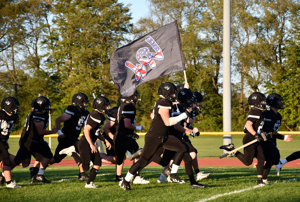 A football team running onto a field. 