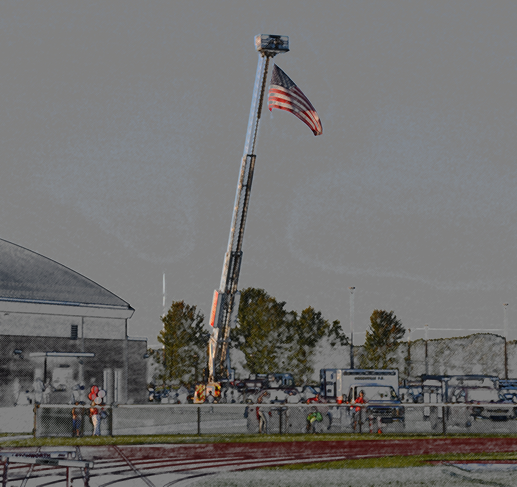 An American flag hoisted on a fire truck. 