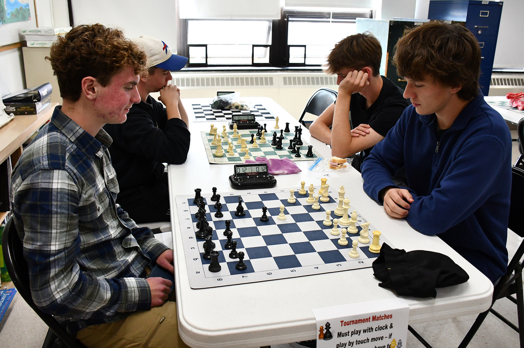 Four high school students playing chess. 