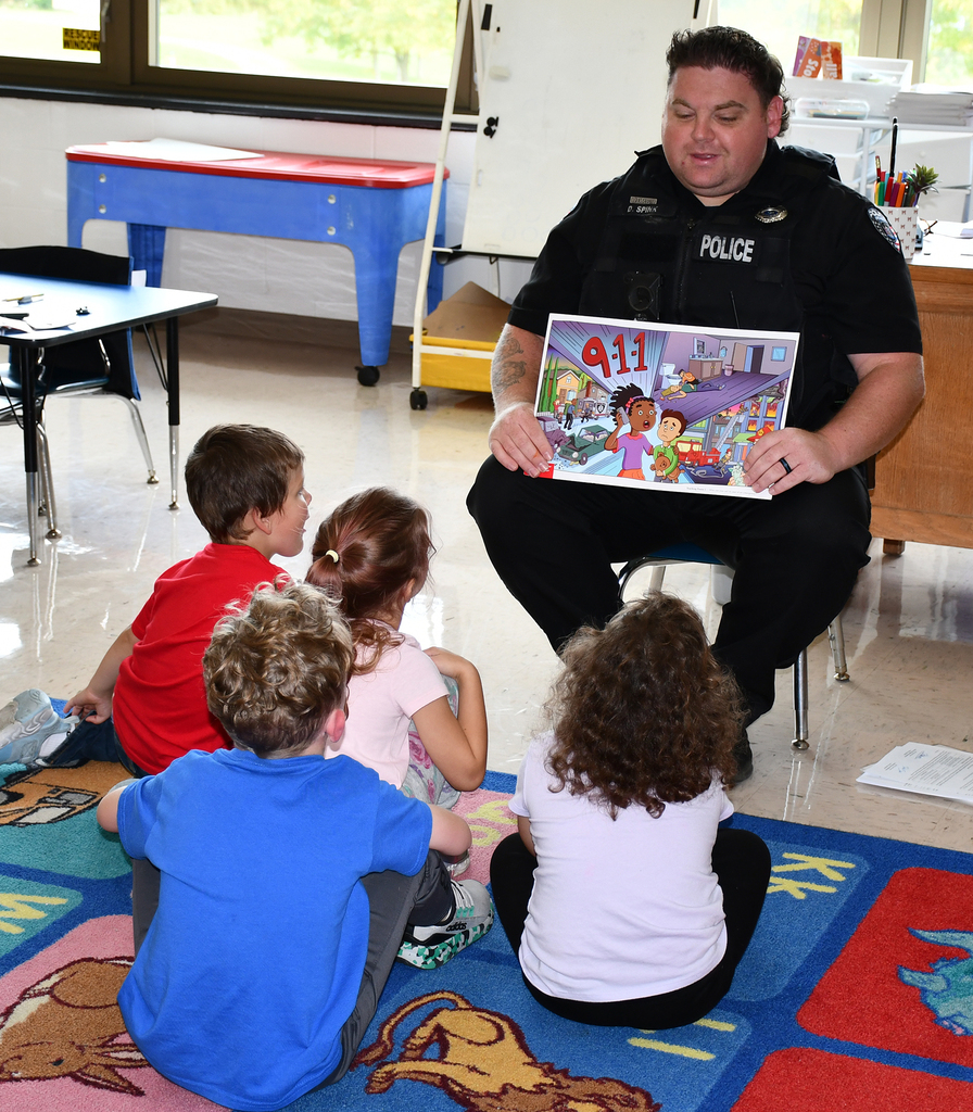 A police officer speaking with elementary children. 