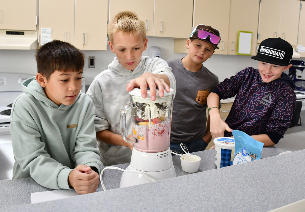 Four junior high students using a blender. 