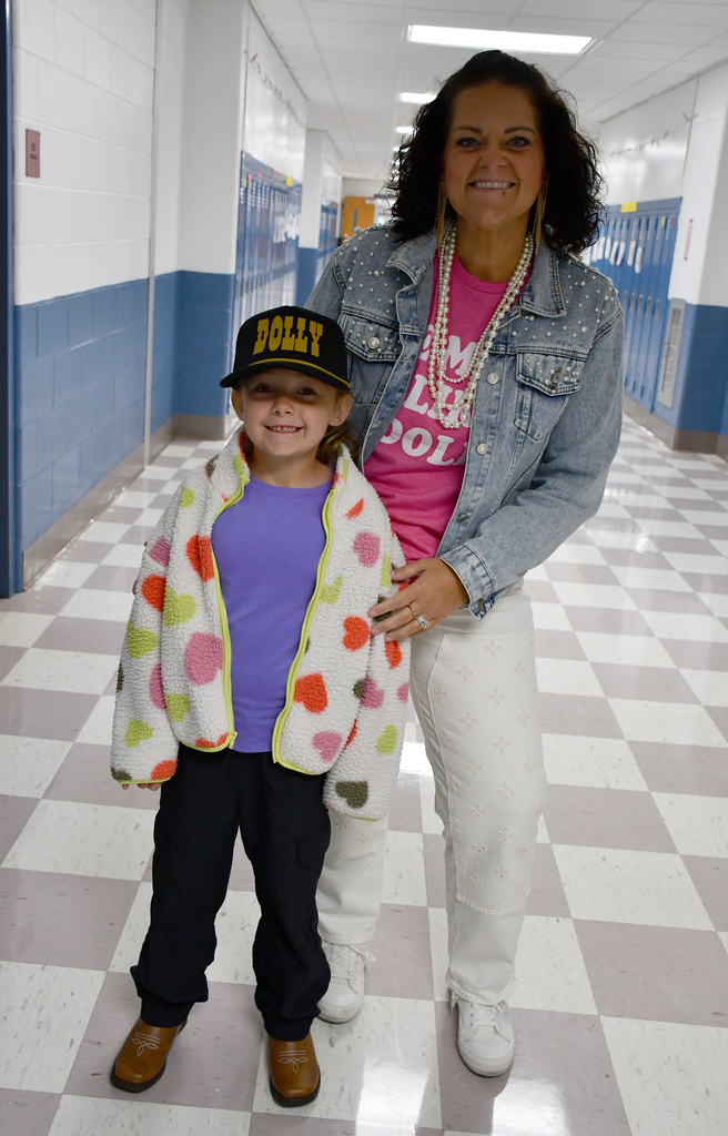 A child standing in a school hallway with an adult. 