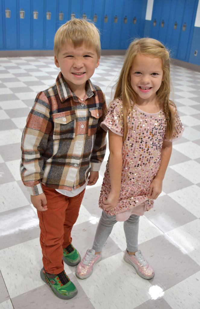 A boy in a flannel shirt and a girl in a sparkle dress. 