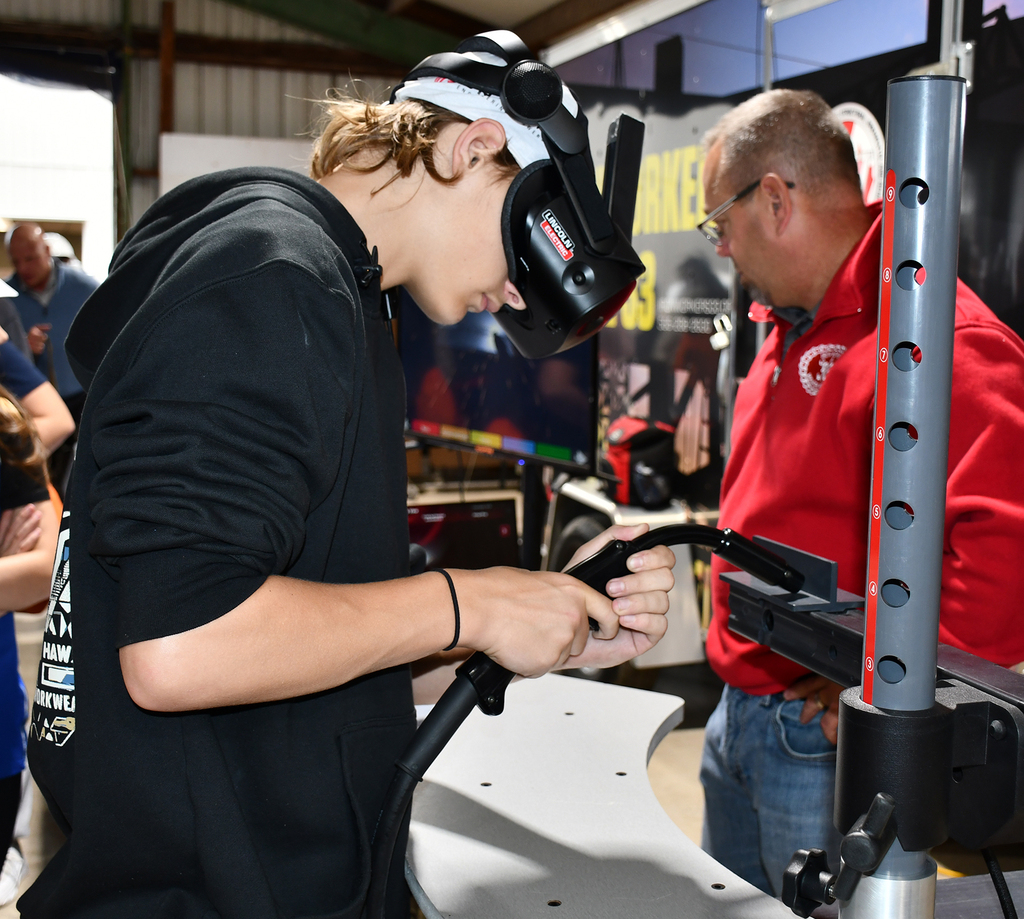 A student operating a welding simulator. 