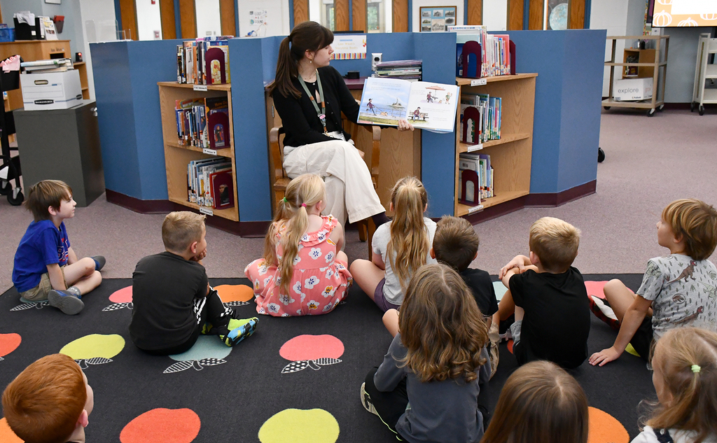 An adult reading to a group of children. 