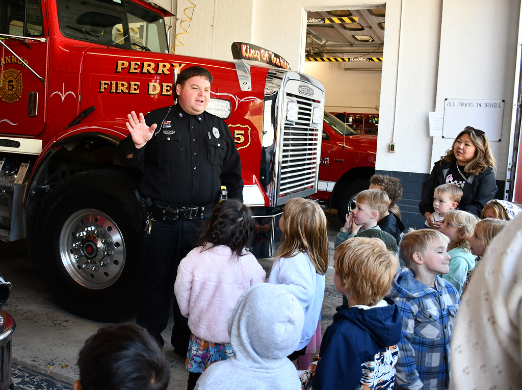An adult showing students a fire truck. 
