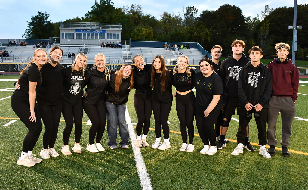 A group of students standing on a football field. 