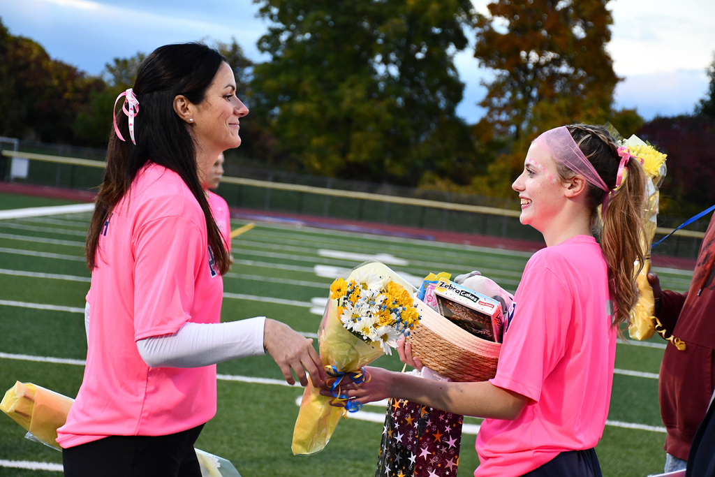A coach handing flowers to a soccer player. 