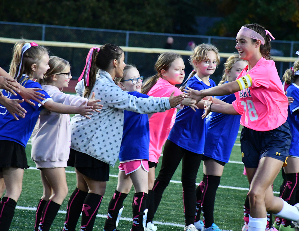 A soccer player high-fiving other soccer players. 