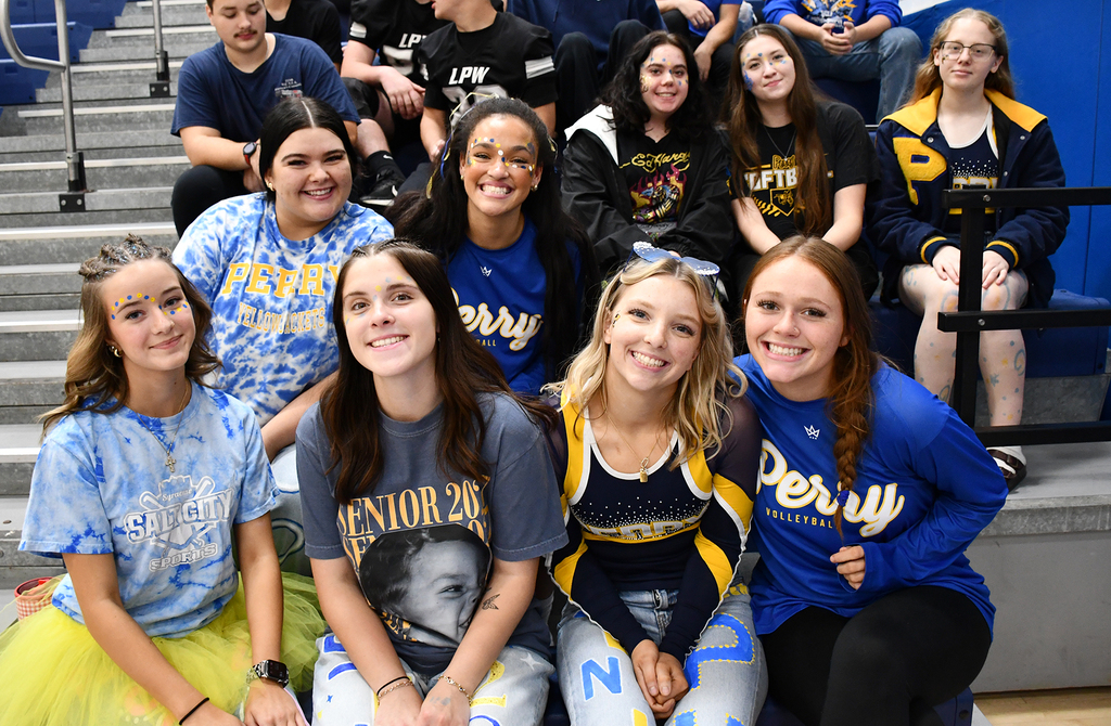 A group of high school kids sitting on gym bleachers. 