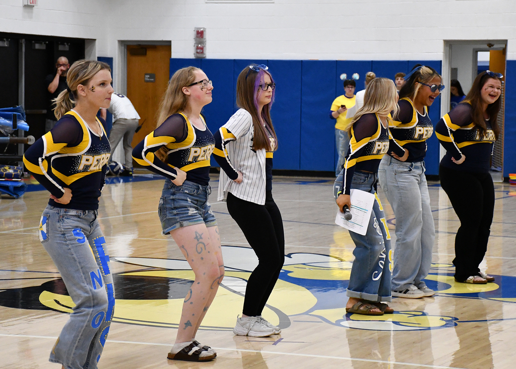 Six students dancing in the middle of a gym floor. 