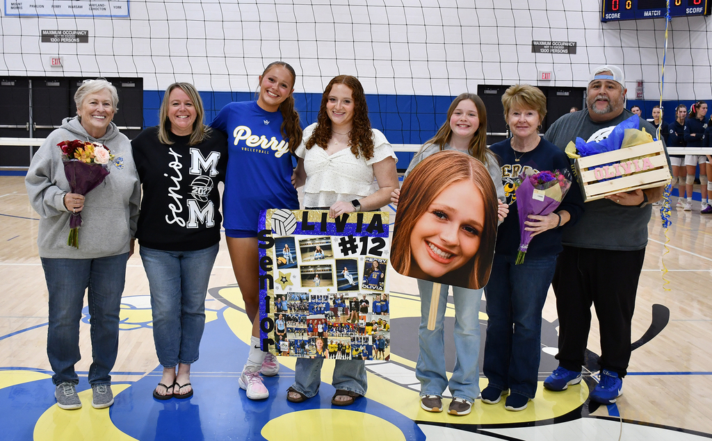 A family posing for a photo in a school gym. 