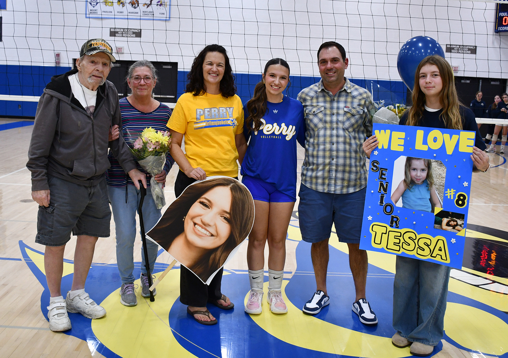 A family posing together in a school gymnasium. 