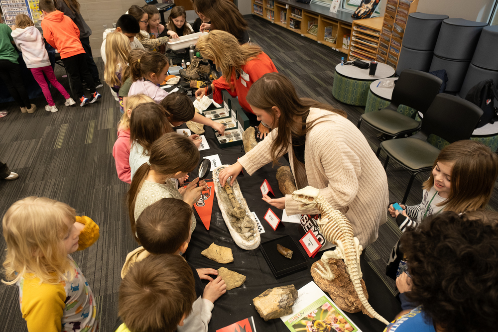 Megan Buchheit shows a dinosaur bone to Primary Center students